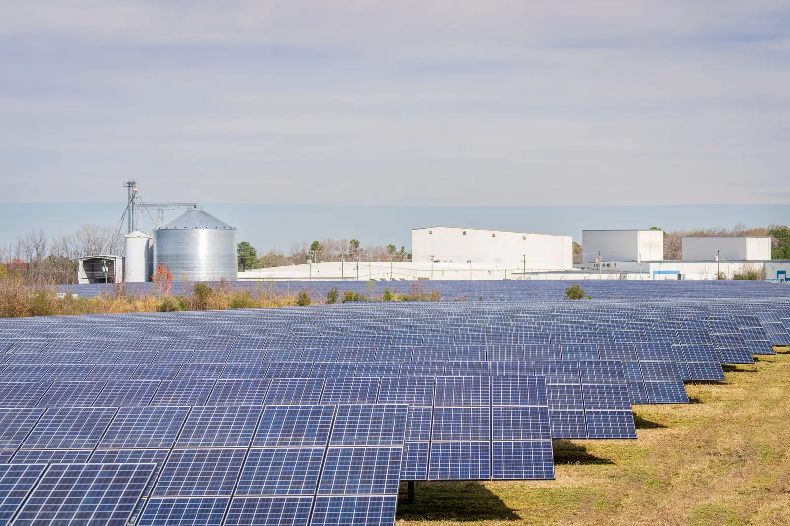 Solar panels beside an industrial plant