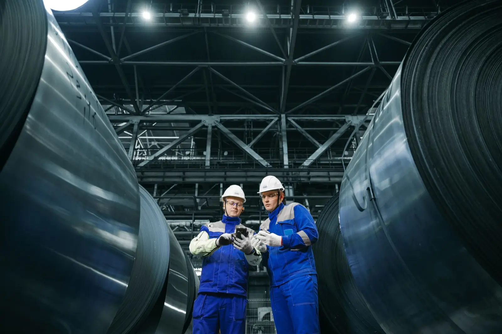 Engineers inspecting steel coils in a modern plant