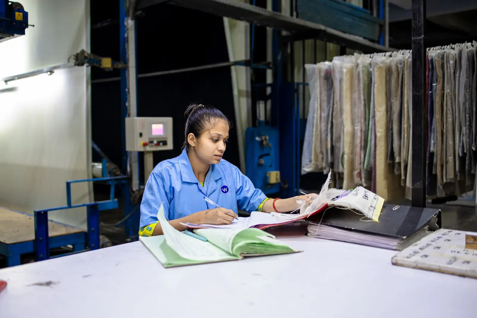 Factory worker updating quality records at her workstation